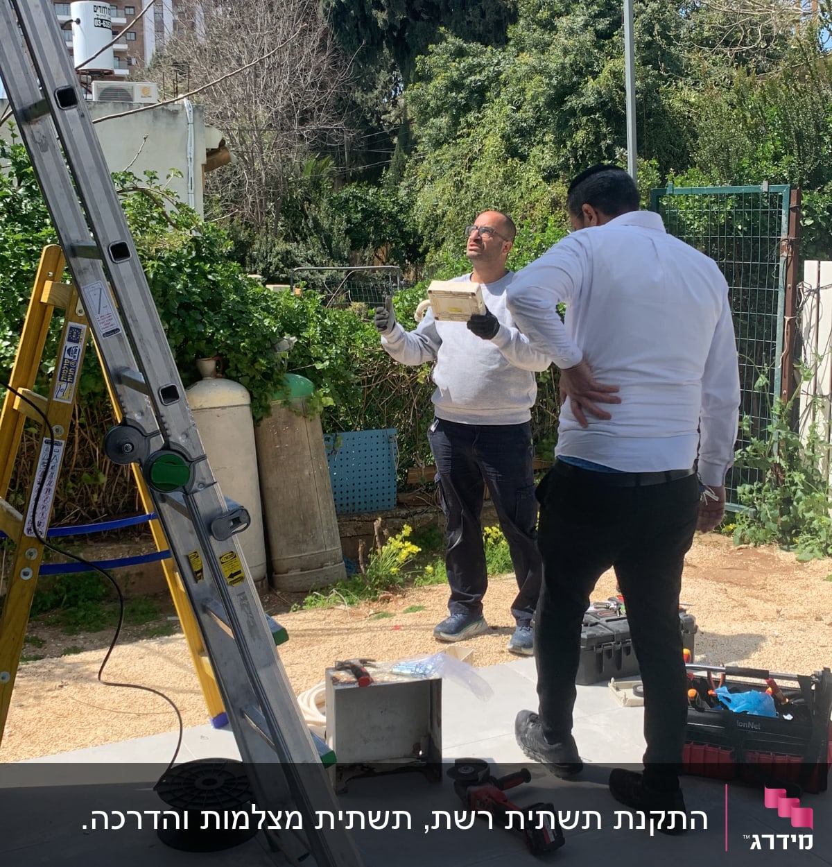 טכנאי רשת עם סולם, כלי עבודה וכבלים בחוץ